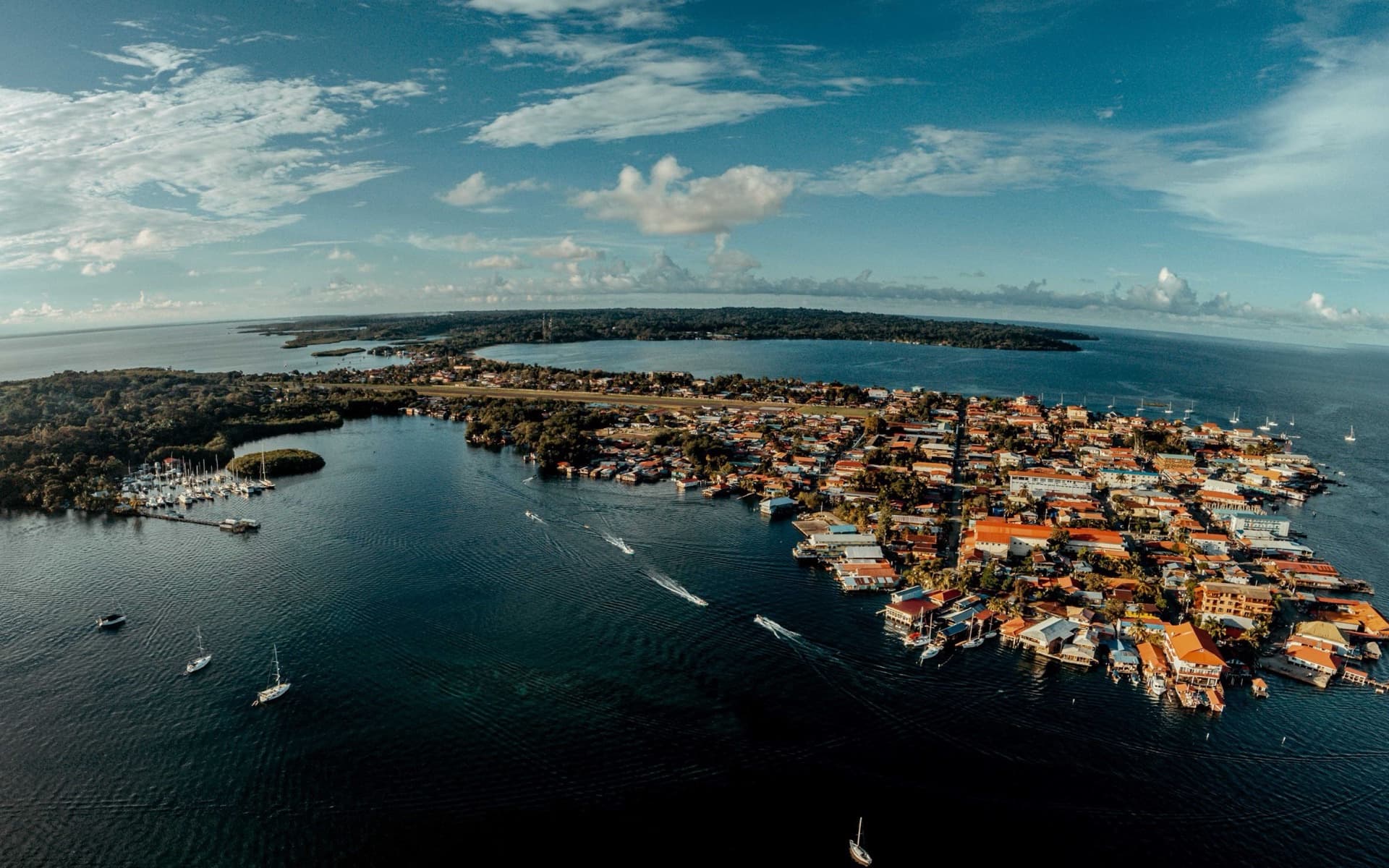 Aerial view of Bocas Town on Isla Colón, with waterfront buildings on stilts, water taxis and sailboats moored offshore